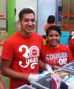Two representatives from the Hispanic Business Student Association volunteer time at the Houston Food Bank.